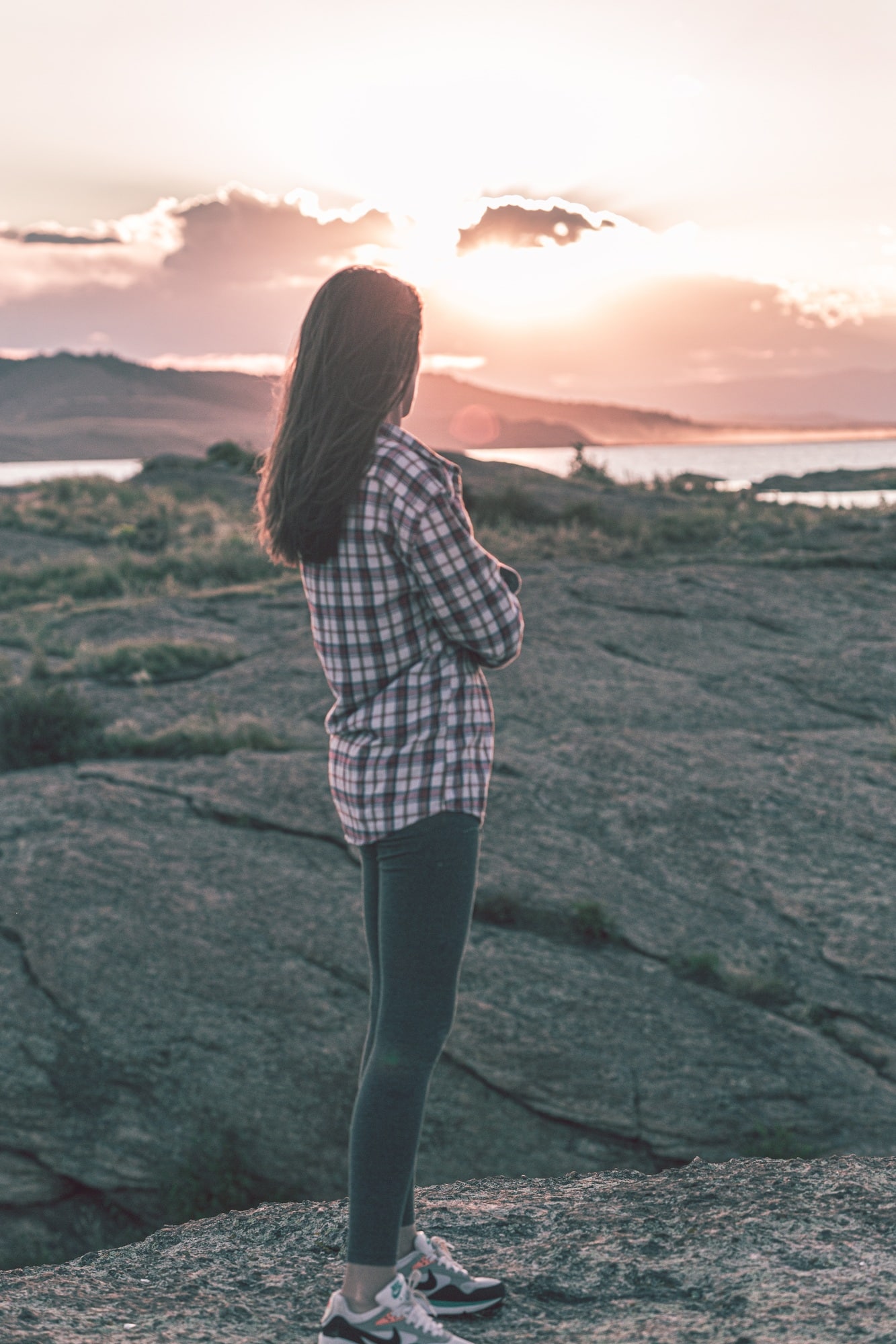 Young lady watching sunset in the mountains of Colorado. Mental health.
